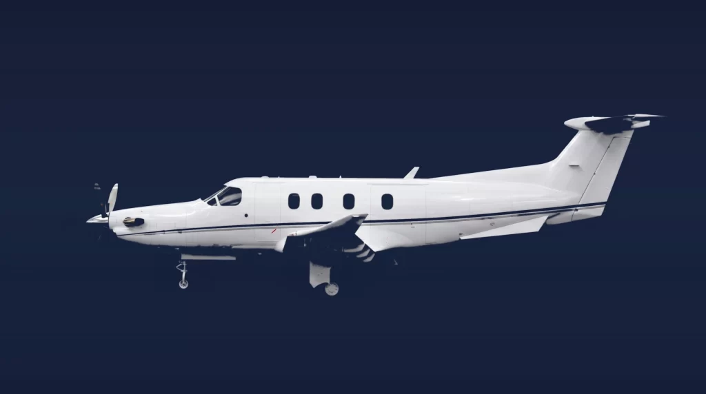 Pilatus PC-12 PRO private charter aircraft, left-side profile on a deep navy studio background